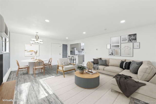 living room featuring an inviting chandelier and light hardwood / wood-style floors