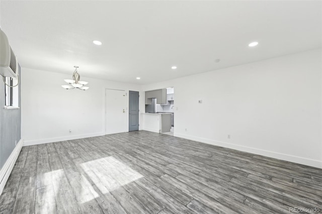 unfurnished living room with hardwood / wood-style flooring and a chandelier