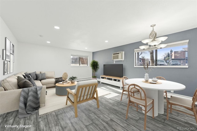 living room featuring hardwood / wood-style flooring, a wall mounted AC, and an inviting chandelier