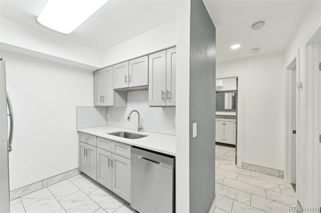 kitchen with gray cabinets, sink, stainless steel dishwasher, and decorative backsplash