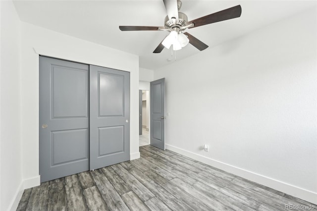 unfurnished bedroom with light hardwood / wood-style flooring, a closet, and ceiling fan