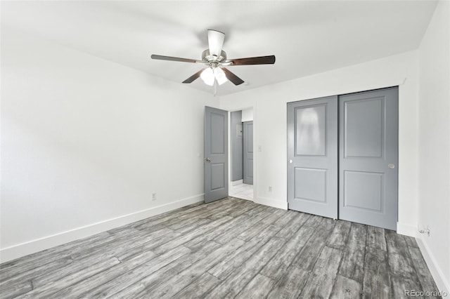 unfurnished bedroom featuring light hardwood / wood-style flooring, a closet, and ceiling fan