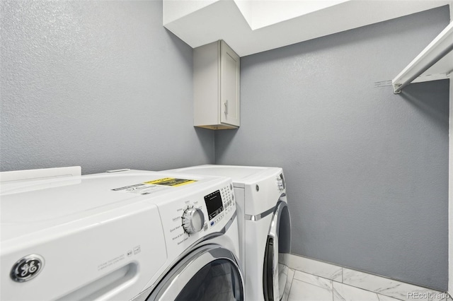 laundry room featuring cabinets and washer and dryer