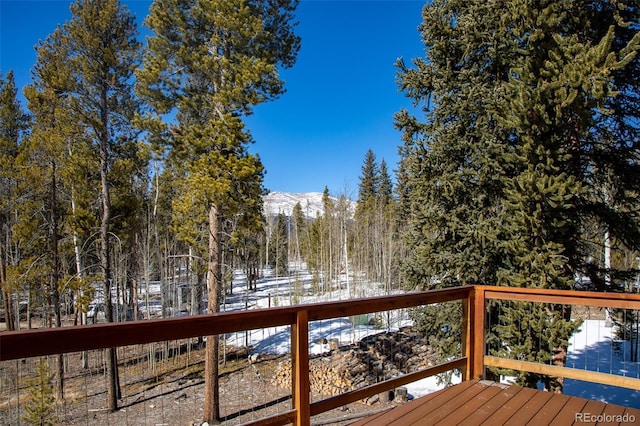 wooden deck featuring a mountain view and a view of trees