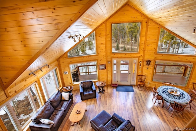 living area featuring high vaulted ceiling, wooden ceiling, wood walls, and wood finished floors