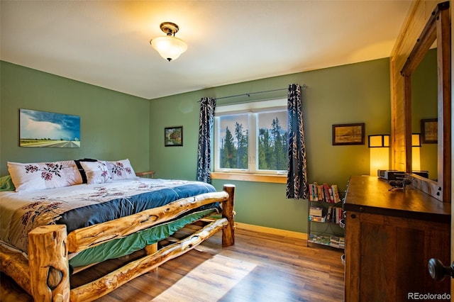 bedroom featuring baseboards and wood finished floors