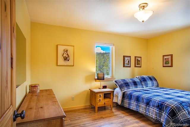 bedroom featuring baseboards and wood finished floors