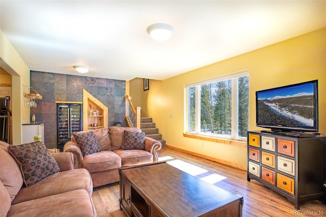 living area with light wood finished floors, stairs, baseboards, and tile walls