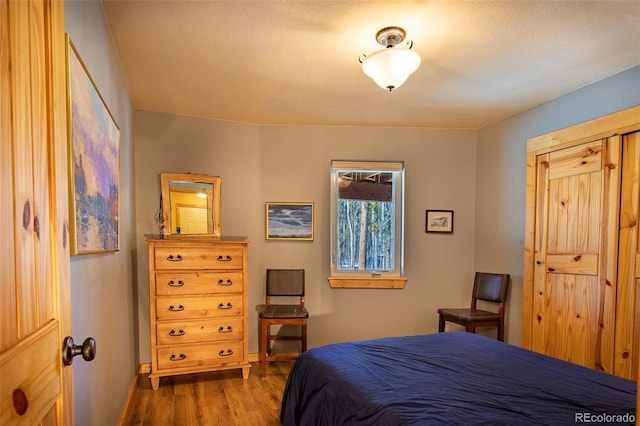 bedroom featuring baseboards and wood finished floors