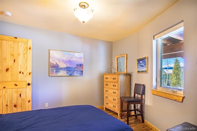 bedroom featuring baseboards and wood finished floors