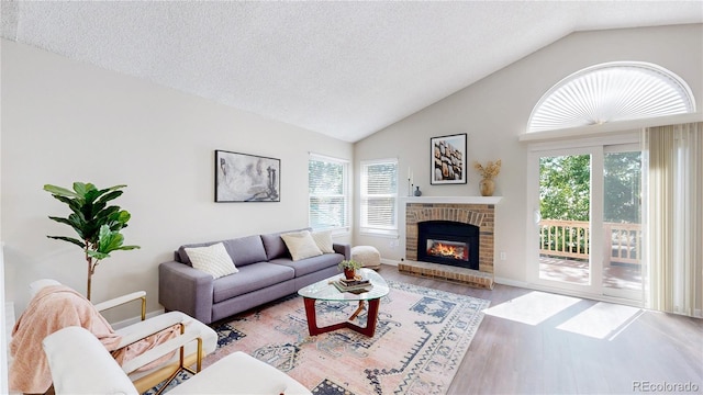 3755 Shefield Dr, Broomfield, CO 80020 - living room featuring healthy amount of natural light, wood finished floors, a fireplace, a textured ceiling, and high vaulted ceiling