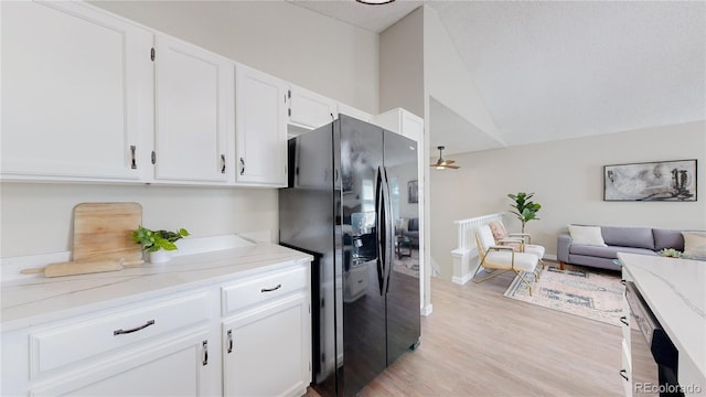3755 Shefield Dr, Broomfield, CO 80020 - kitchen featuring black fridge with ice dispenser, white cabinets, light stone countertops, lofted ceiling, and light wood-style flooring