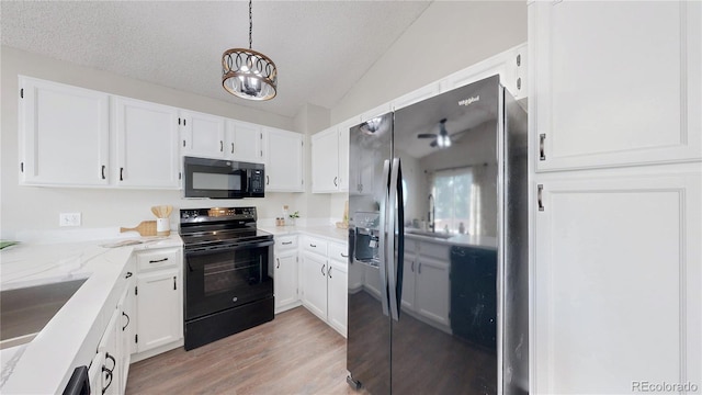 3755 Shefield Dr, Broomfield, CO 80020 - kitchen with black appliances, lofted ceiling, white cabinetry, light wood finished floors, and a textured ceiling