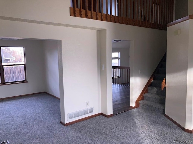 empty room featuring carpet and a high ceiling