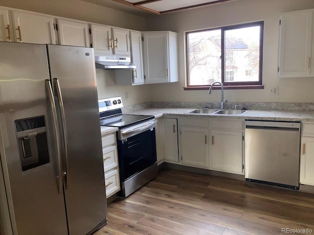 kitchen featuring white cabinets, appliances with stainless steel finishes, hardwood / wood-style flooring, and sink