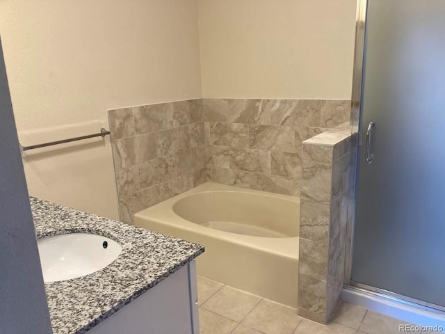 bathroom with a tub, tile patterned flooring, and vanity