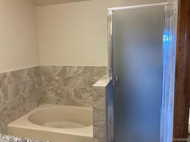 bathroom featuring toilet and shower with separate bathtub