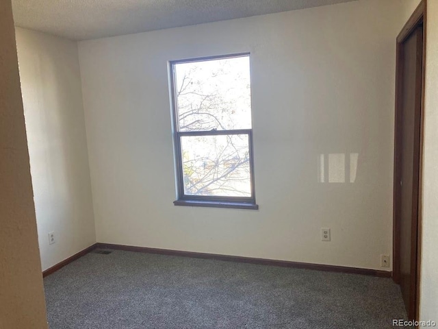 carpeted spare room featuring a textured ceiling