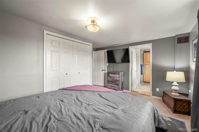 carpeted bedroom featuring a closet and a textured ceiling