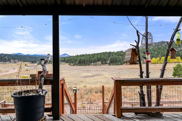 view of yard featuring a rural view and a deck with mountain view