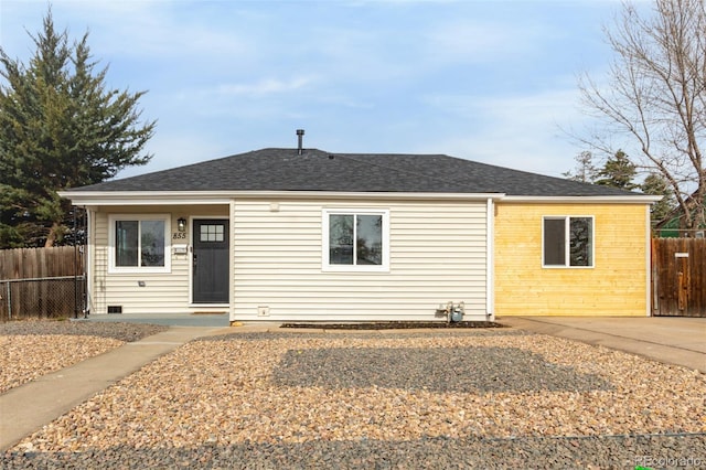 view of front facade featuring roof with shingles and fence