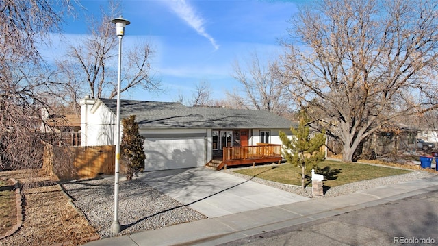 single story home featuring a wooden deck, a front yard, and a garage