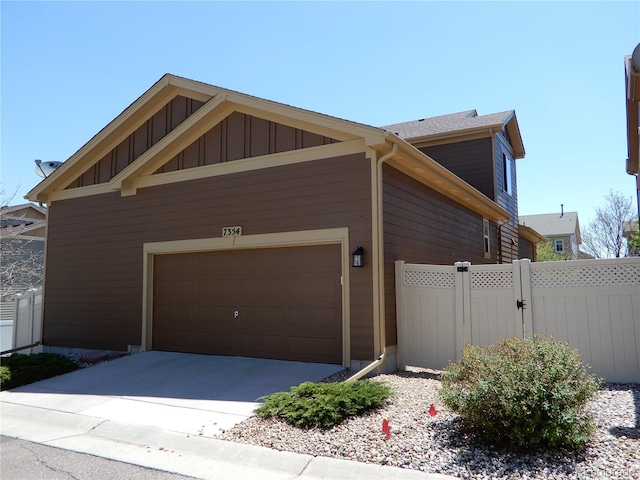 7354 Benton St, Arvada, CO 80003 - view of side of home with fence, board and batten siding, and a garage