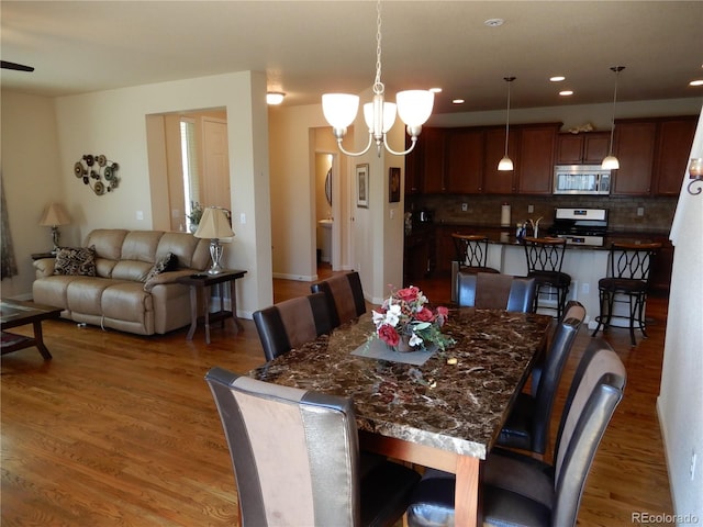 7354 Benton St, Arvada, CO 80003 - dining room with wood finished floors, a chandelier, and recessed lighting