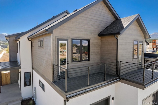 view of side of property with a mountain view and a balcony