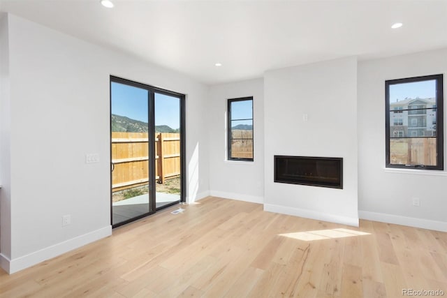 unfurnished living room featuring light hardwood / wood-style floors and a wealth of natural light