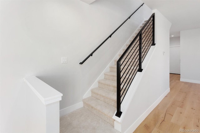 staircase with hardwood / wood-style floors