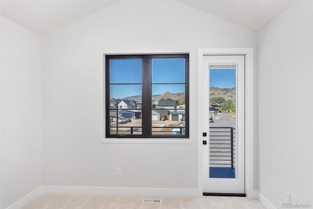 doorway featuring lofted ceiling and light colored carpet