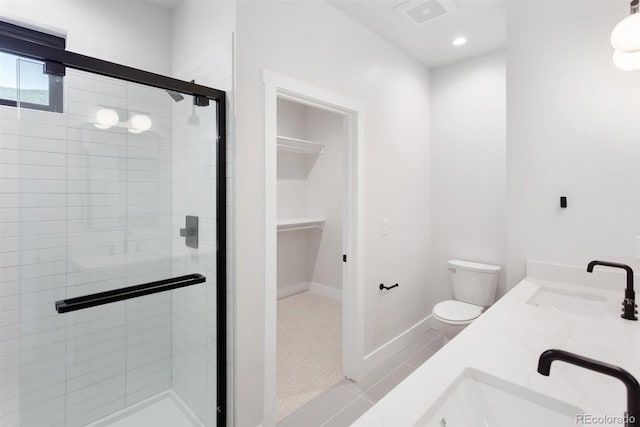 bathroom with vanity, a shower with shower door, toilet, and tile patterned floors