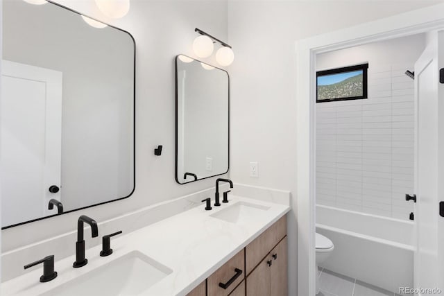 full bathroom featuring tile patterned floors, tiled shower / bath, vanity, and toilet