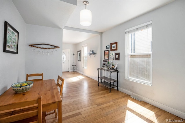 dining area featuring a wealth of natural light, visible vents, light wood-type flooring, and baseboards