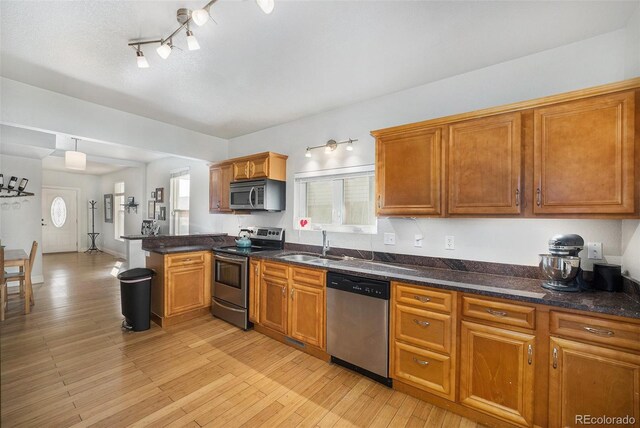 3629 Kalamath St, Denver, CO 80211 - kitchen with stainless steel appliances, a sink, a peninsula, and brown cabinets