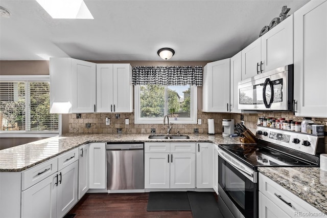 6062 S Newport St, Centennial, CO 80111 - kitchen with stainless steel appliances, a sink, healthy amount of natural light, and white cabinetry
