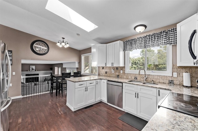 6062 S Newport St, Centennial, CO 80111 - kitchen with a sink, appliances with stainless steel finishes, a peninsula, a skylight, and backsplash