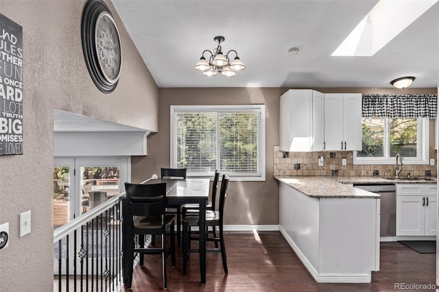 6062 S Newport St, Centennial, CO 80111 - kitchen featuring a sink, stainless steel dishwasher, white cabinets, decorative backsplash, and dark wood finished floors