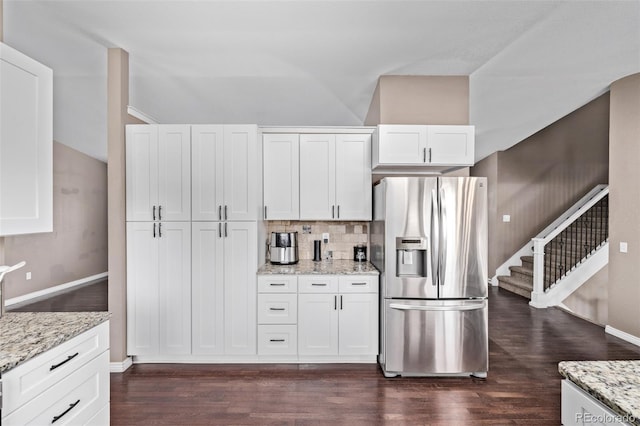 6062 S Newport St, Centennial, CO 80111 - kitchen featuring stainless steel fridge, vaulted ceiling, dark wood finished floors, white cabinets, and decorative backsplash