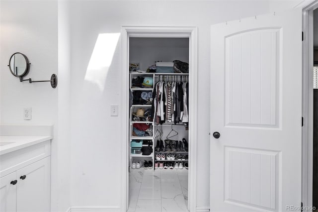 6062 S Newport St, Centennial, CO 80111 - bathroom with marble look tiles, vanity, and a walk in closet