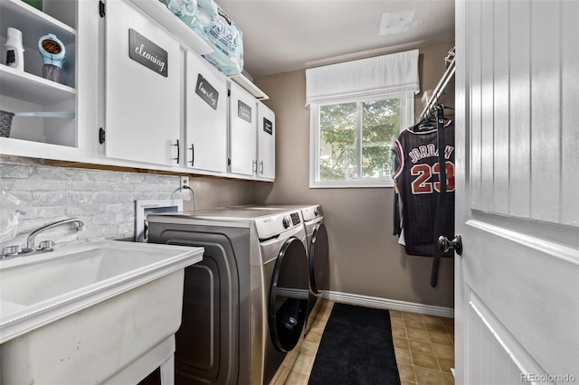 6062 S Newport St, Centennial, CO 80111 - laundry area featuring washer and clothes dryer, cabinet space, light tile patterned floors, and baseboards