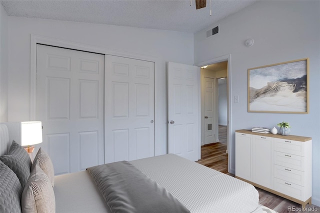 2938 Eliot Cir, Westminster, CO 80030 - bedroom with dark wood-style flooring, lofted ceiling, a closet, and a textured ceiling