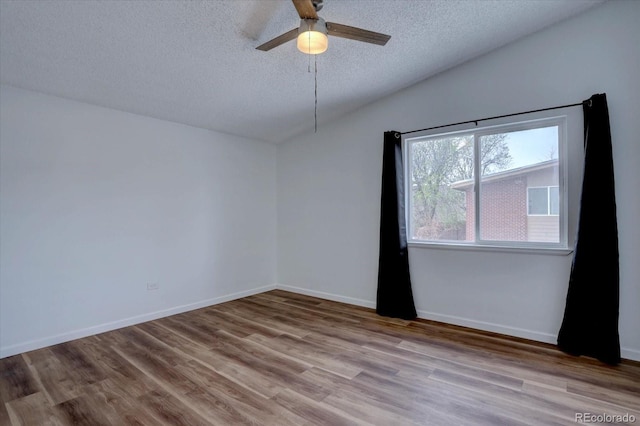 2938 Eliot Cir, Westminster, CO 80030 - spare room featuring a textured ceiling, wood finished floors, ceiling fan, baseboards, and lofted ceiling