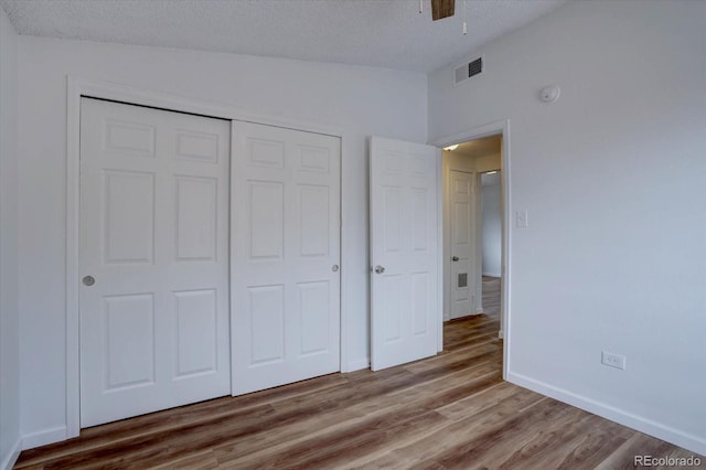 2938 Eliot Cir, Westminster, CO 80030 - unfurnished bedroom with a closet, lofted ceiling, wood finished floors, a textured ceiling, and baseboards