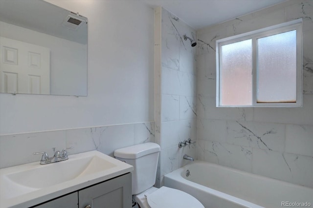 2938 Eliot Cir, Westminster, CO 80030 - bathroom with tile walls, toilet, vanity, bathing tub / shower combination, and a wainscoted wall
