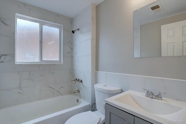 2938 Eliot Cir, Westminster, CO 80030 - bathroom featuring toilet, washtub / shower combination, vanity, tile walls, and a wainscoted wall