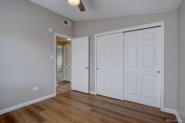 2938 Eliot Cir, Westminster, CO 80030 - unfurnished bedroom with wood finished floors, vaulted ceiling, baseboards, a closet, and a textured ceiling