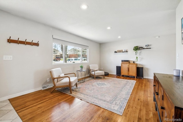 sitting room featuring light wood-style flooring, recessed lighting, visible vents, and baseboards