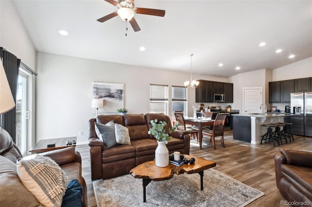 living room with sink, hardwood / wood-style flooring, and ceiling fan with notable chandelier